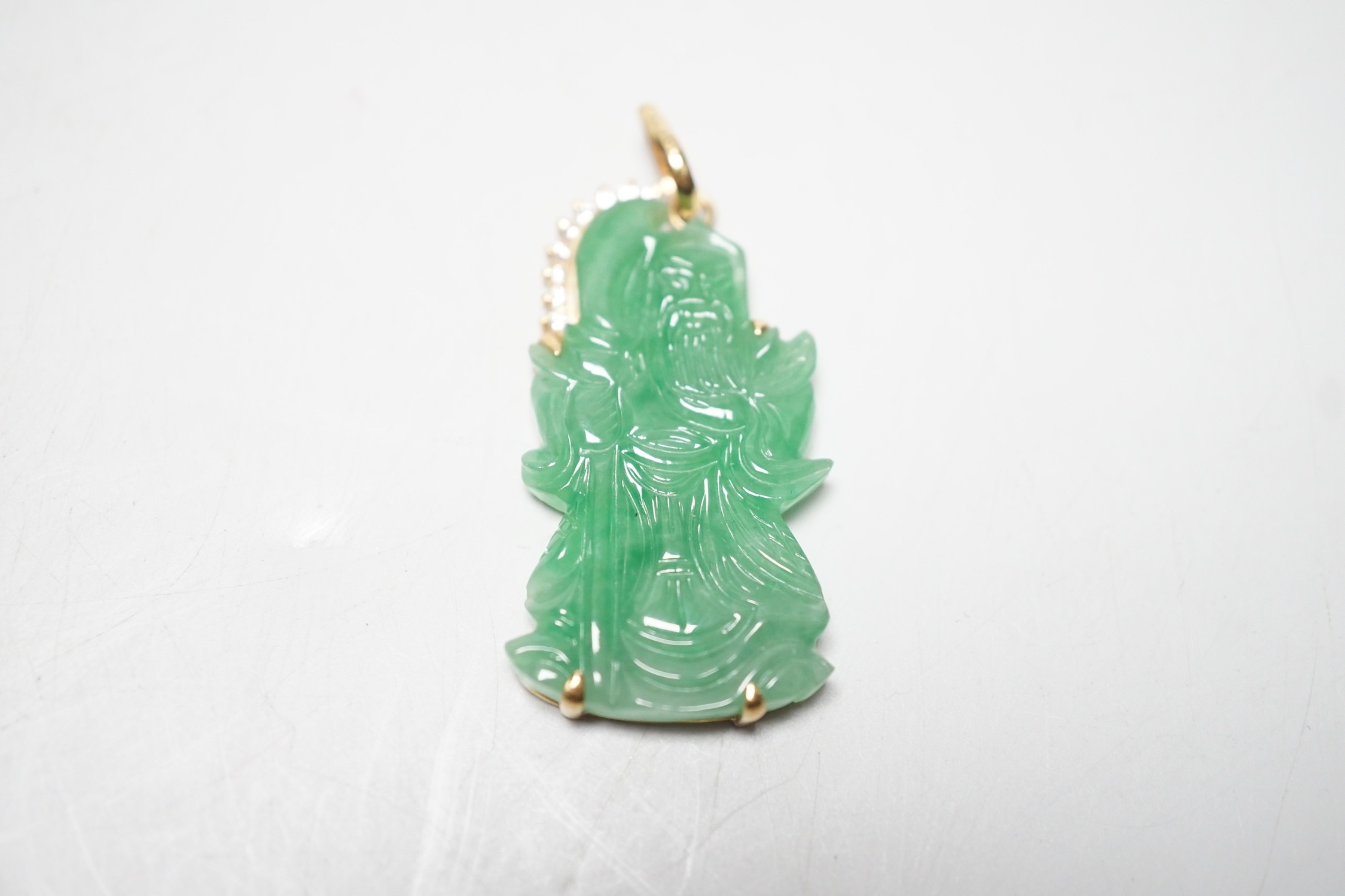 A modern 18k and diamond chip mounted jadeite pendant, carved as an immortal, 40mm, gross weight 9.1 grams.